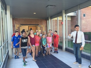Music Teacher Andrew Mullen has his students walk in rhythm as part of a warm-up exercise.