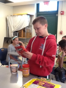 A 6th Grade boy inspecting the nutrition facts of a bag of doritos.